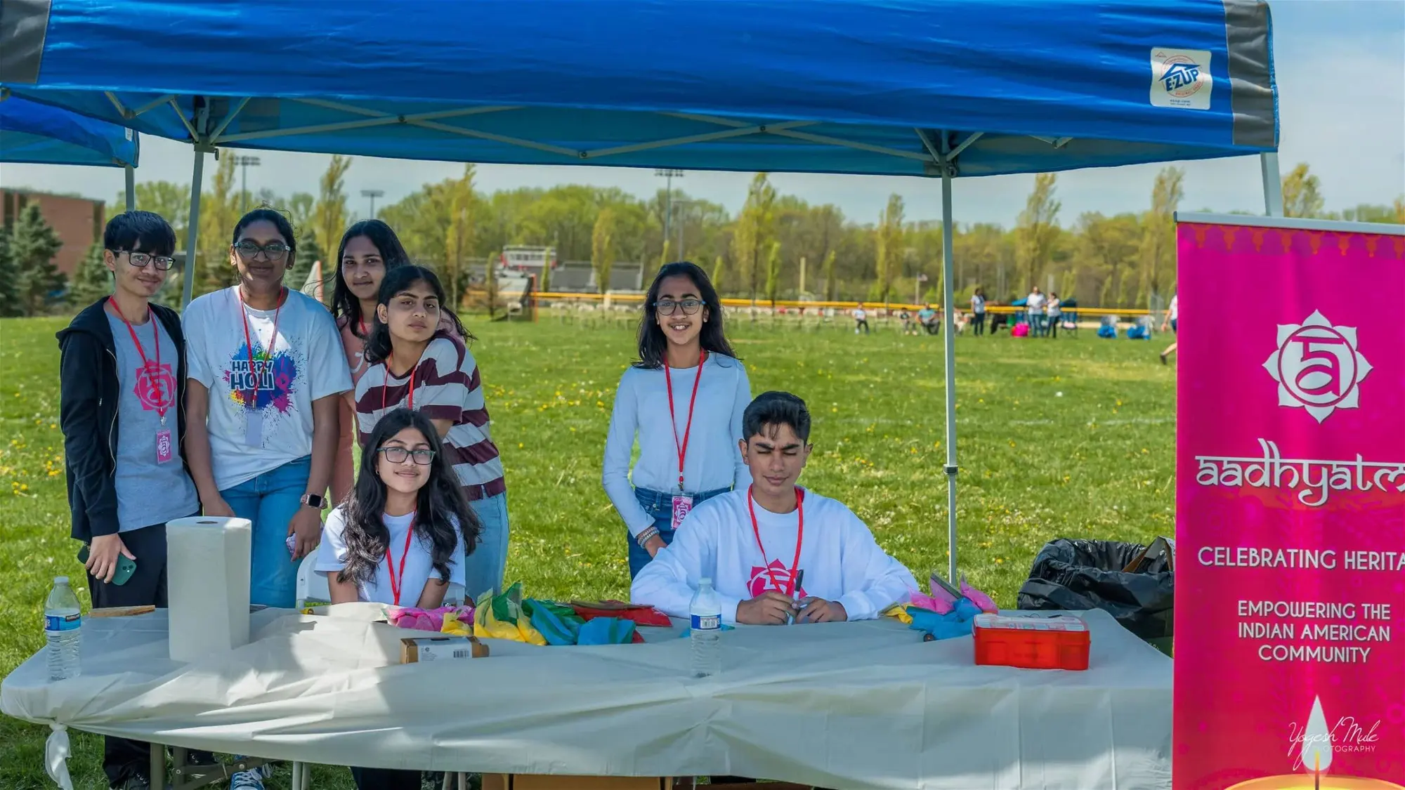 Youth volunteers run the aadhyatmik welcome booth beside the lotus banner