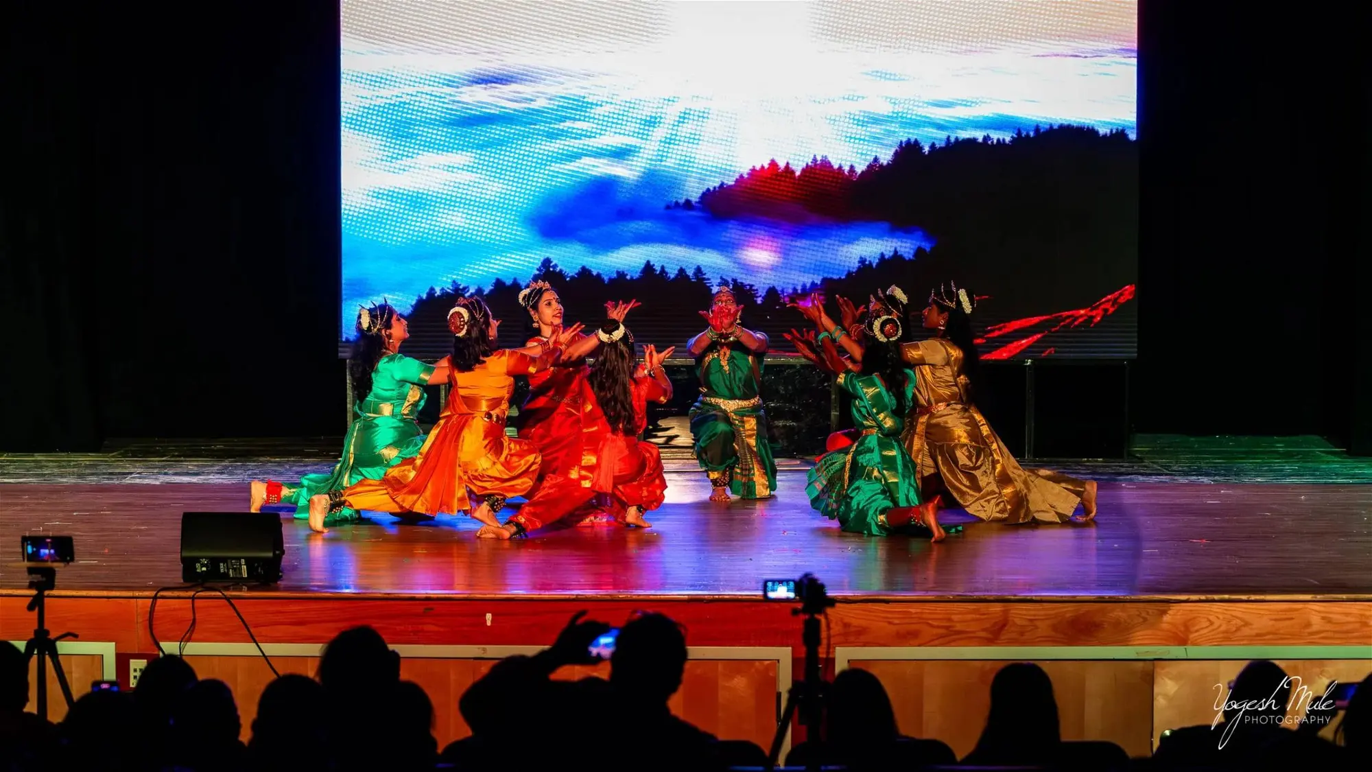 Dancers perform under blue and orange stage light at the Diwali cultural show
