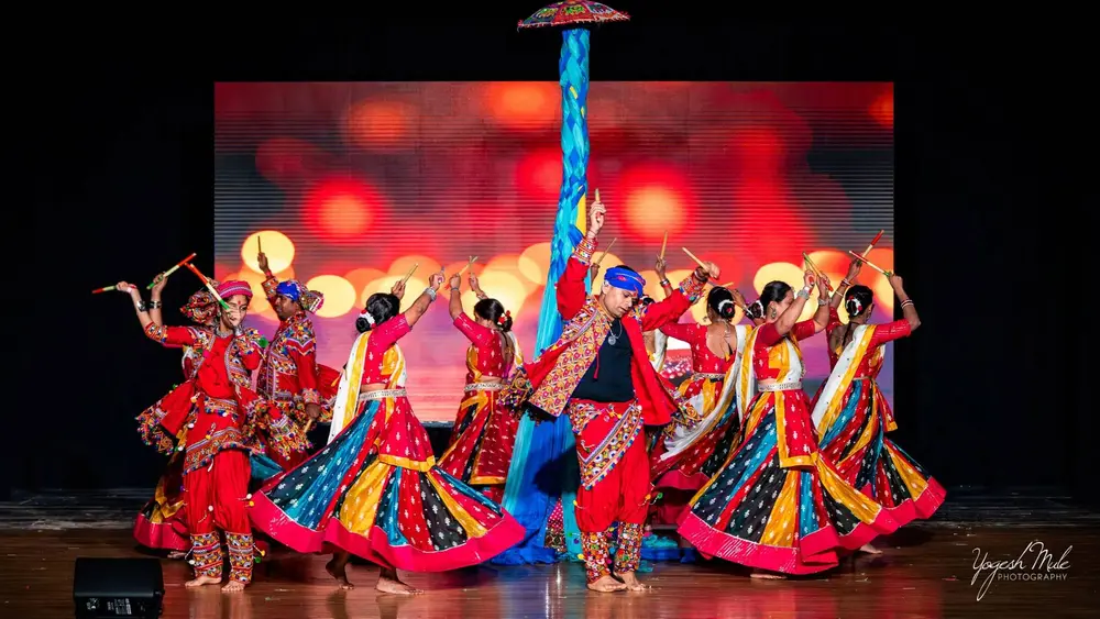 Dancers in mirrored chaniya choli spin through a garba performance on stage