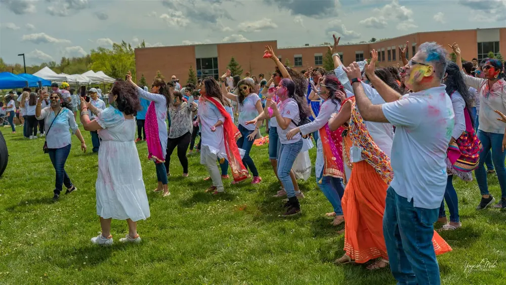 A crowd dances to music across the Holi grounds