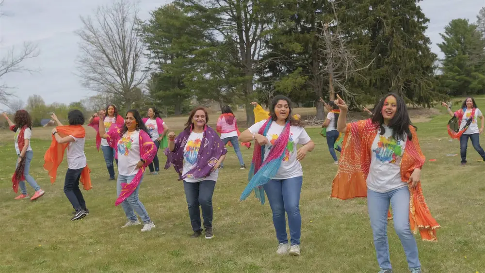 Dancers wave bright dupattas across the open field at Robbinsville Holi