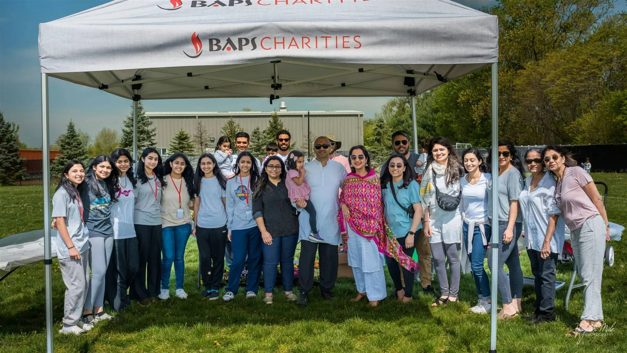 Volunteers and families gather under a charity tent at Robbinsville Holi