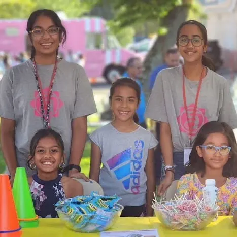 Youth volunteers run a games booth for children