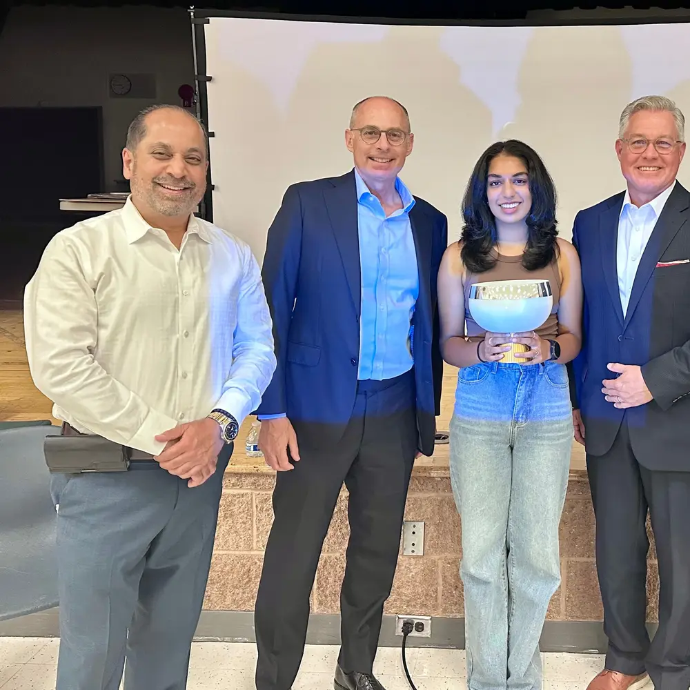 A youth leader stands with community and civic leaders after being recognised
