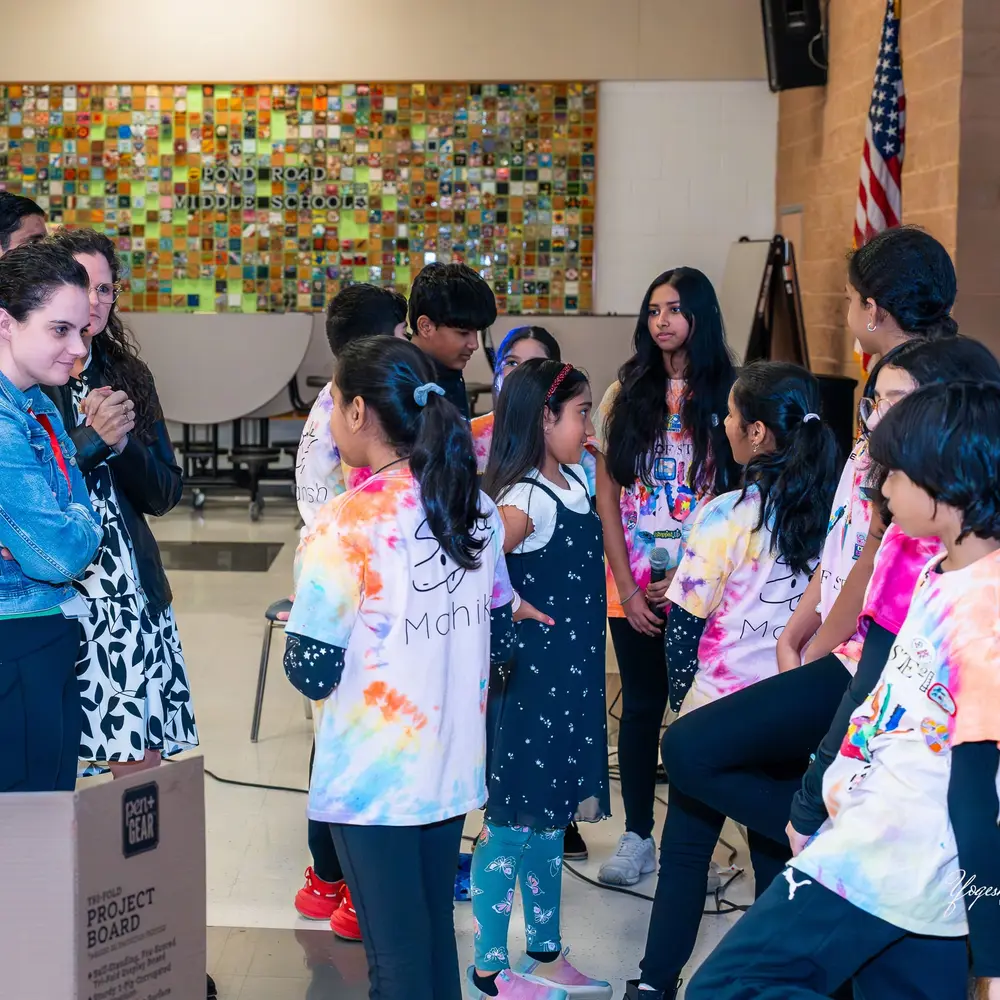 Young attendees in colourful shirts watch a Sangat session