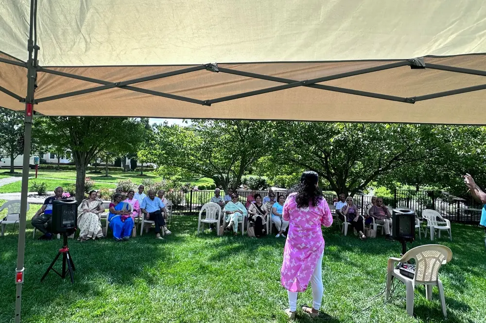 Seniors seated outdoors under a canopy for a Sanskriti session in the park