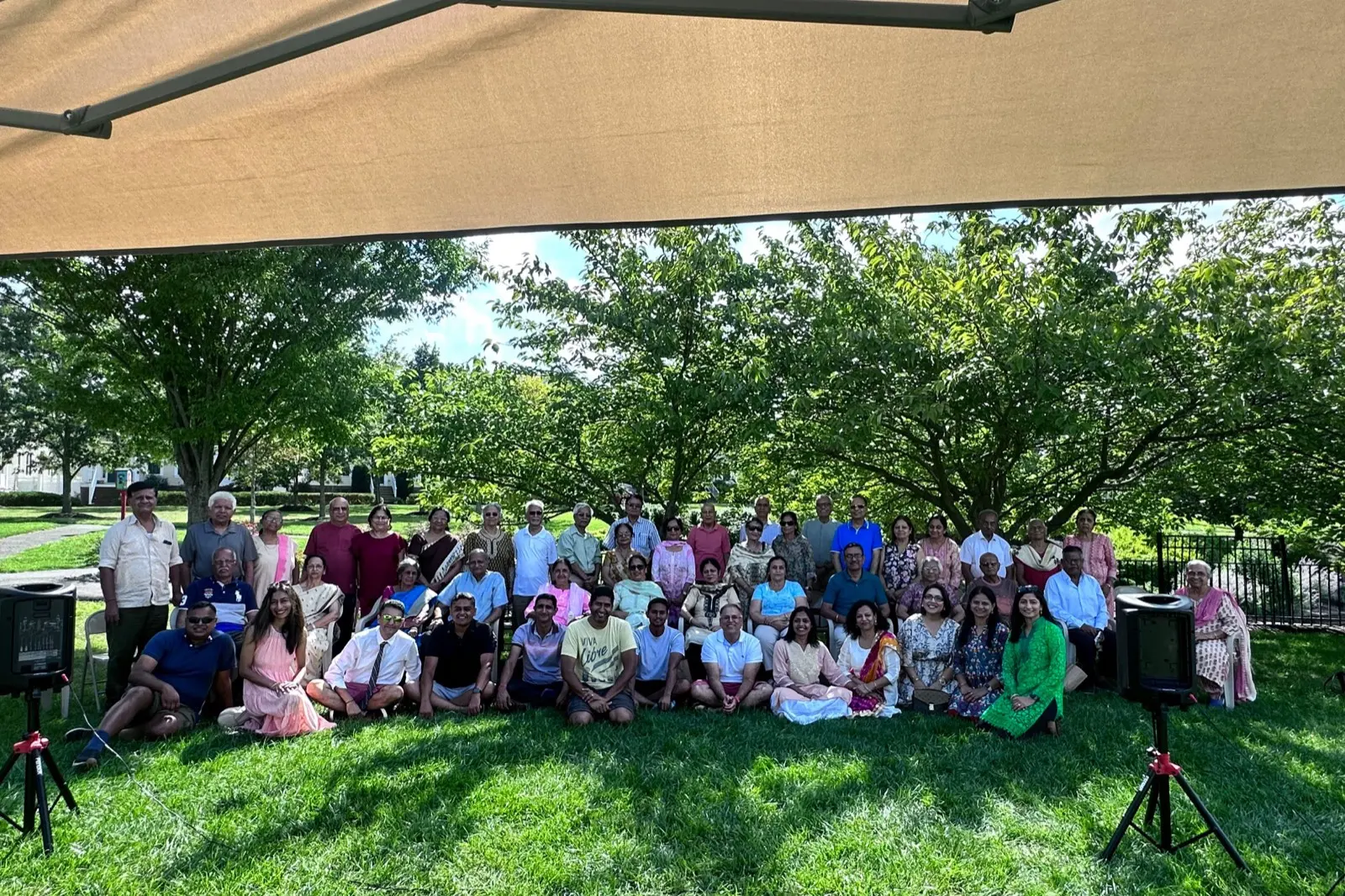 A large group of seniors and families on the lawn at the Sanskriti summer picnic
